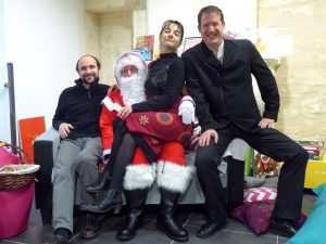Stefan Denk, Laure Pauliat et Damien Barbier assis autour du père Noël après une animation de la mule lyrique à Mouthiers